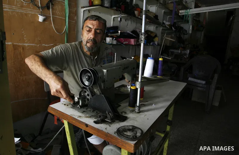A Palestinian tailor sews school bags before the start of school season at his workshop in Rafah in the southern Gaza Strip, on Sep. 01, 2014. Calm returned to the coastal enclave in a August 26 ceasefire, and Gazans wer...
