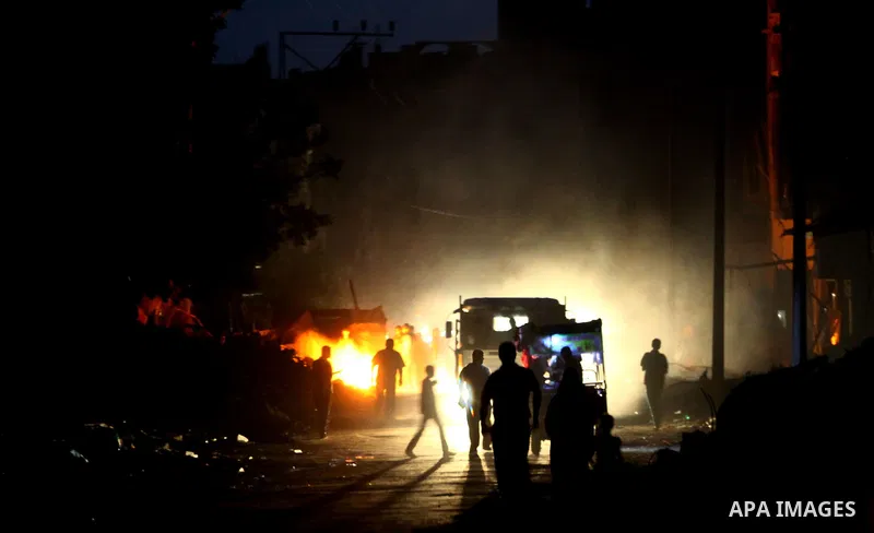 Palestinians gather around the fire inside the remains of their house that witnesses said were destroyed in an Israeli offensive, after a ceasefire was declared in the Shejaia neighbourhood, east of Gaza City. September...