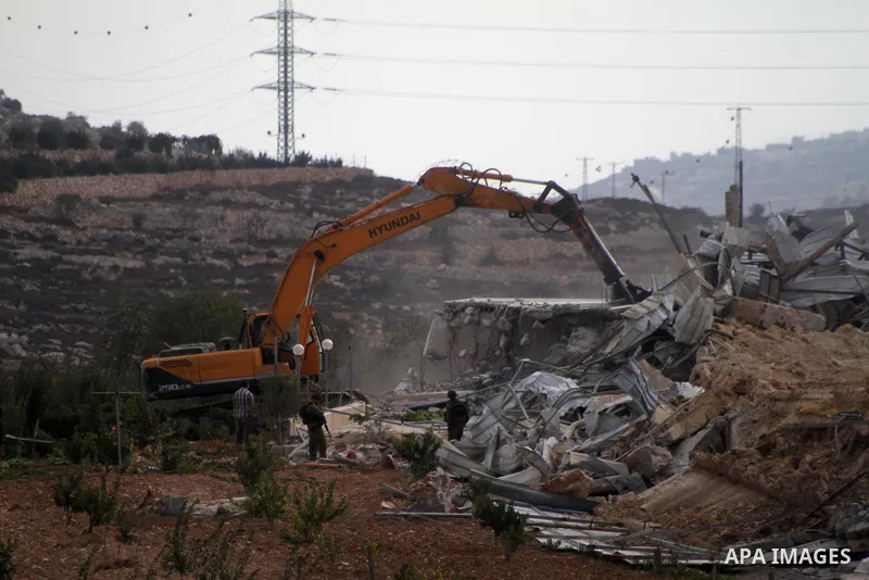 An Israeli bulldozer demolishes a dairy factory, at the al-Rama neighborhood near the West Bank city of Hebron on September 2, 2014. Israeli bulldozers demolished a dairy factory in Hebron and Bedouin homes east of Jerus...