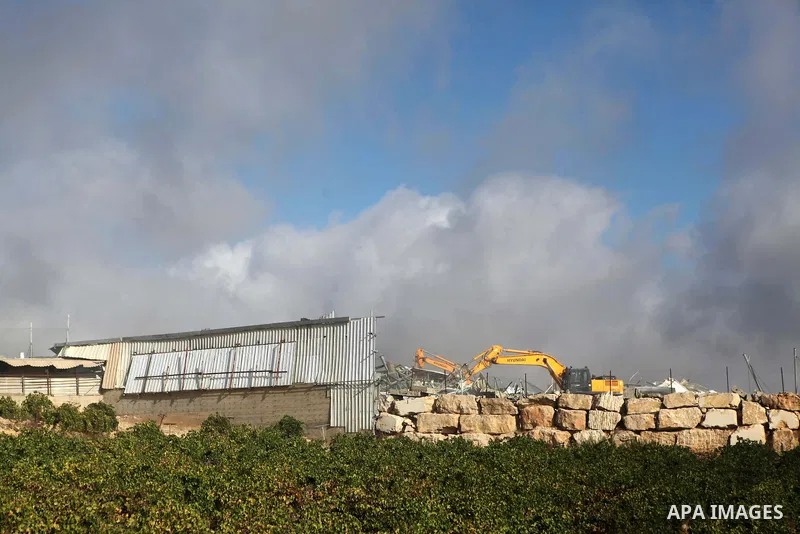 An Israeli bulldozer demolishes a dairy factory, at the al-Rama neighborhood near the West Bank city of Hebron on September 2, 2014. Israeli bulldozers demolished a dairy factory in Hebron and Bedouin homes east of Jerus...