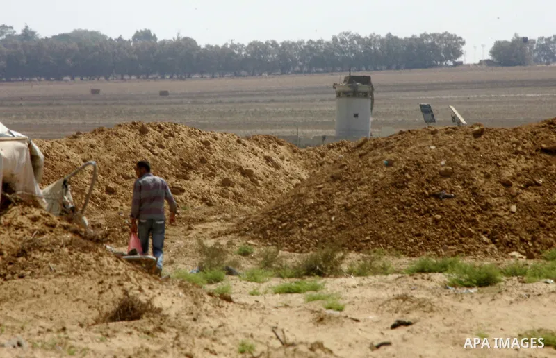 A Palestinian man inspects his farmland which destroyed during fighting between Hamas militants and Israel near the Israeli Gaza border fence in east of Khan Younis, southern Gaza Strip September 2, 2014. An open-ended c...