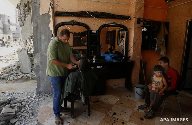 A palestinian barber works at his shop which destroyed during fighting between Hamas militants and Israel in Absan near the border between Israel and east of the town of Khan Yunis in the southern Gaza Strip September 2,...