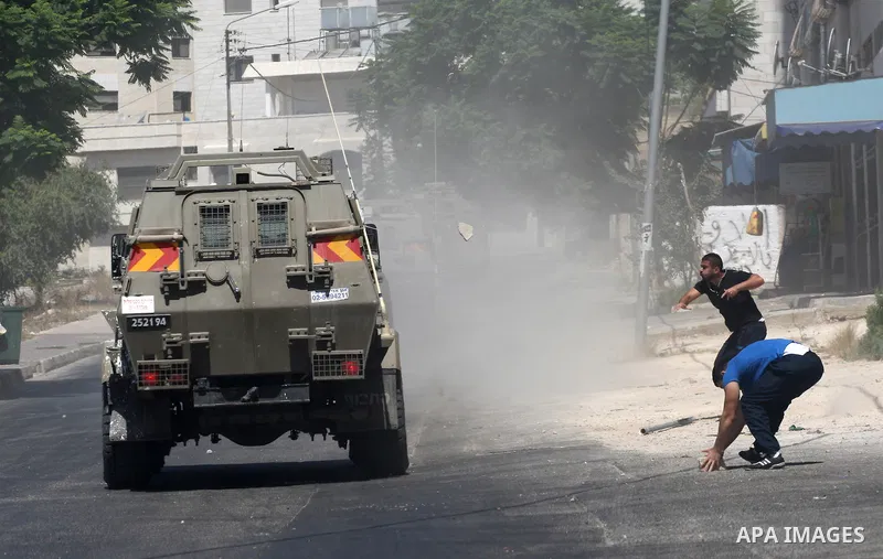 Palestinian youths throw at Israeli military patrols during a military operation at Ein Beit Alma' refugee camp near the West Bank city of Nablus, on Sep. 03, 2014. Photo by Nedal Eshtayah
