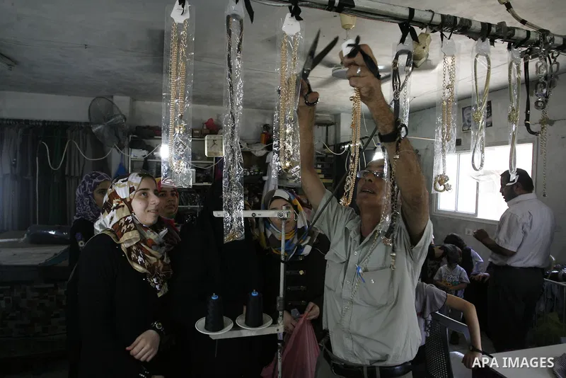 A Palestinian man tailor sews clothes at a workshop in Rafah in the southern Gaza Strip, on Sep. 04, 2014. Calm returned to the coastal enclave in a August 26 ceasefire, and Gazans were gradually starting to rebuild thei...