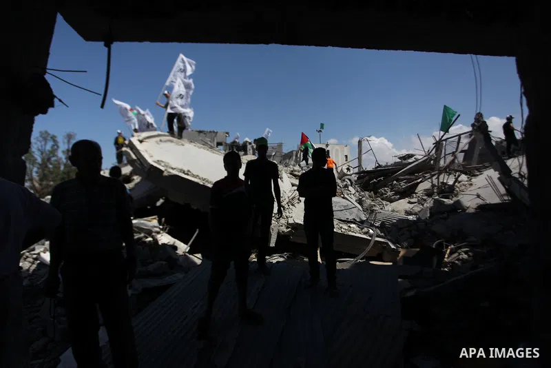 Palestinians hold national flags during a protest in the Shejaia neighbourhood, east of Gaza City. September 6, 2014. Calm returned to the coastal enclave in a August 26 ceasefire, and Gazans were gradually starting to r...