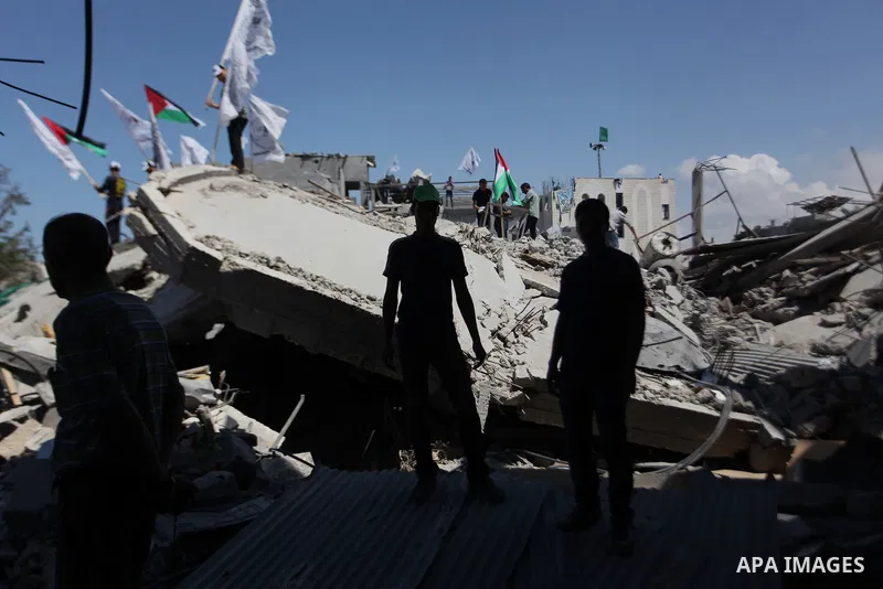 Palestinians hold national flags during a protest in the Shejaia neighbourhood, east of Gaza City. September 6, 2014. Calm returned to the coastal enclave in a August 26 ceasefire, and Gazans were gradually starting to r...
