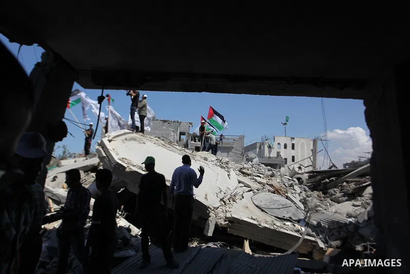 Palestinians hold national flags during a protest in the Shejaia neighbourhood, east of Gaza City. September 6, 2014. Calm returned to the coastal enclave in a August 26 ceasefire, and Gazans were gradually starting to r...