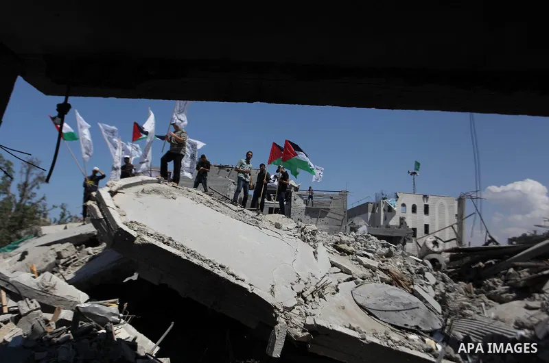 Palestinians hold national flags during a protest in the Shejaia neighbourhood, east of Gaza City. September 6, 2014. Calm returned to the coastal enclave in a August 26 ceasefire, and Gazans were gradually starting to r...