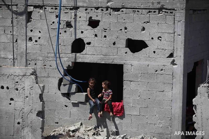 Palestinian children sit on the rubble of their house that witnesses said were destroyed in an Israeli offensive, after a ceasefire was declared in the Shejaia neighbourhood, east of Gaza City. September 6, 2014. Calm re...