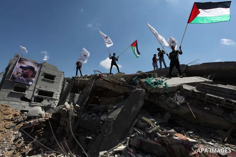 Palestinians hold national flags during a protest in the Shejaia neighbourhood, east of Gaza City. September 6, 2014. Calm returned to the coastal enclave in a August 26 ceasefire, and Gazans were gradually starting to r...