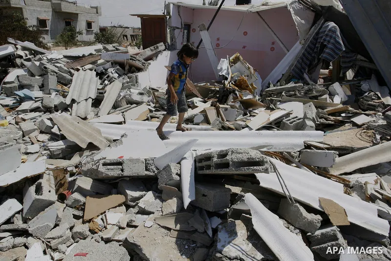 A Palestinian boy walks on the rubble of his famiy's house which destroyed during fighting between Hamas militants and Israel in east of Rafah in southern Gaza strip on September 07, 2014. Calm returned to the coastal en...