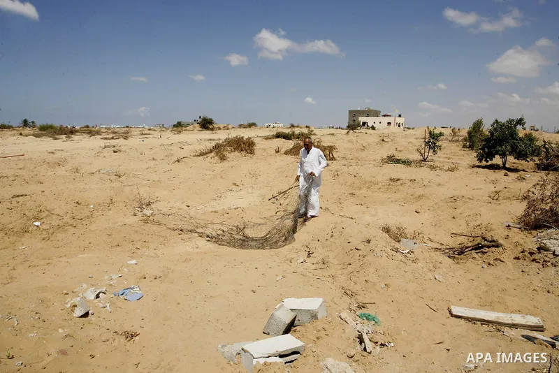 A Palestinian man inspects his farmland which destroyed during fighting between Hamas militants and Israel in east of Rafah in southern Gaza strip on September 07, 2014. Calm returned to the coastal enclave in a August 2...