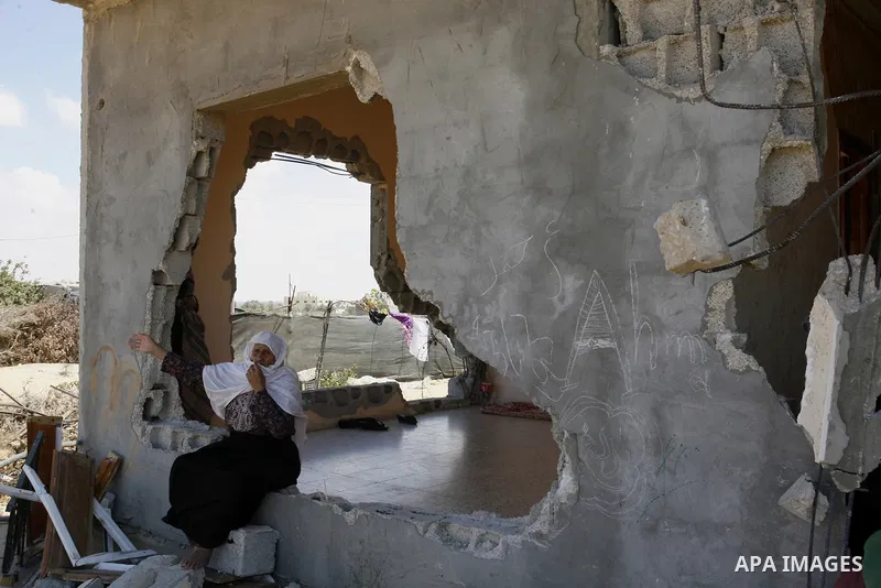 A Palestinian woman sits on the rubble of her house which destroyed during fighting between Hamas militants and Israel in east of Rafah in southern Gaza strip on September 07, 2014. Calm returned to the coastal enclave i...