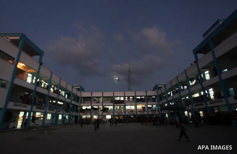 Palestinians watch children play a UN school in Beit Hanoun in northern Gaza strip on Sep. 07, 2014. Calm returned to the coastal enclave in a August 26 ceasefire, and Gazans were gradually starting to rebuild their live...