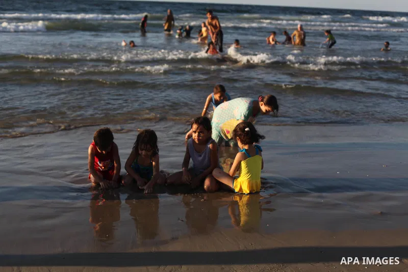 Palestinians enjoy swimming in the sea on Gaza's beach on Sep. 07, 2014. Photo by Ashraf Amra
