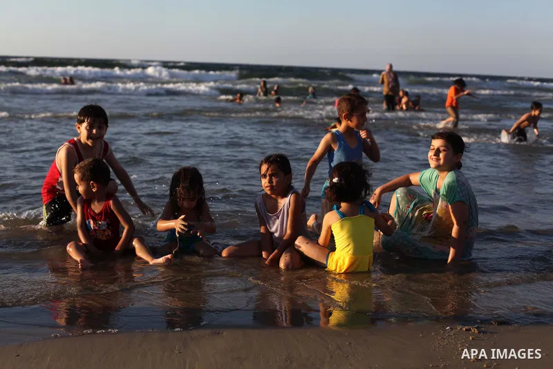 Palestinians enjoy swimming in the sea on Gaza's beach on Sep. 07, 2014. Photo by Ashraf Amra