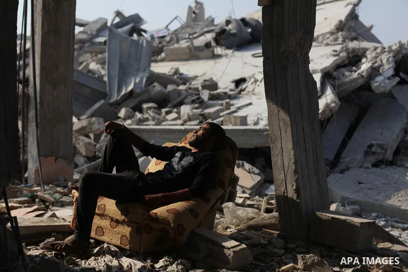 A Palestinian man sits on a sofa on the rubble of his house which destroyed during fighting between Hamas militants and Israel in the center of Gaza strip on September 08, 2014. Calm returned to the coastal enclave in a...