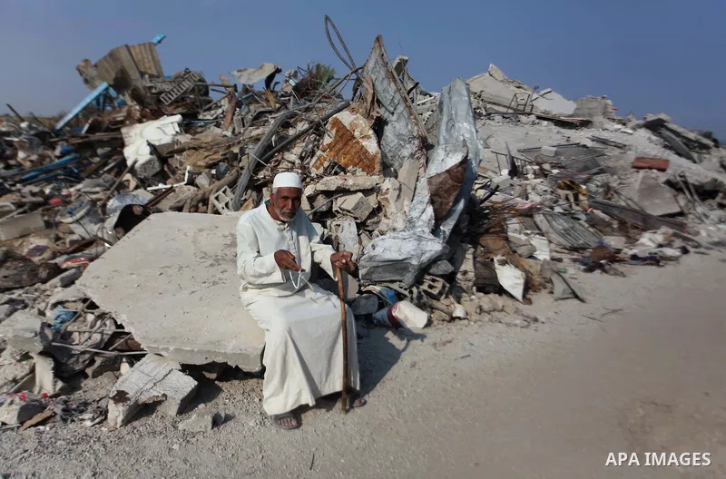 A Palestinian man sits on the rubble of his house which destroyed during fighting between Hamas militants and Israel in the center of Gaza strip on September 08, 2014. Calm returned to the coastal enclave in a August 26...