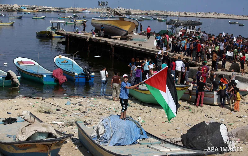 Palestinian children hold flags and banners during a rally to demand break the Israeli blockade on the Gaza strip, in Gaza's seaport on Sep. 08, 2014. Calm returned to the coastal enclave in a August 26 ceasefire, and Ga...