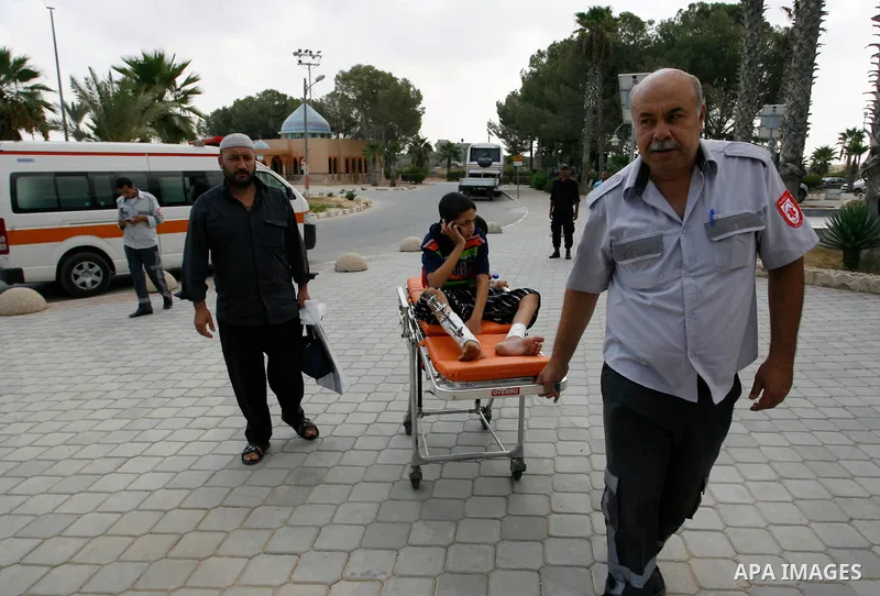 A Palestinian medic wheels a wounded on a stretche child who medics said was wounded during the Israeli offensive on Gaza Strip, waits to be given the permission to cross into Egypt at the Rafah border crossing in the so...