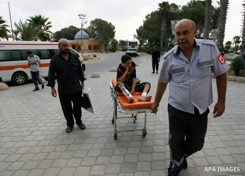 A Palestinian medic wheels a wounded on a stretche child who medics said was wounded during the Israeli offensive on Gaza Strip, waits to be given the permission to cross into Egypt at the Rafah border crossing in the so...