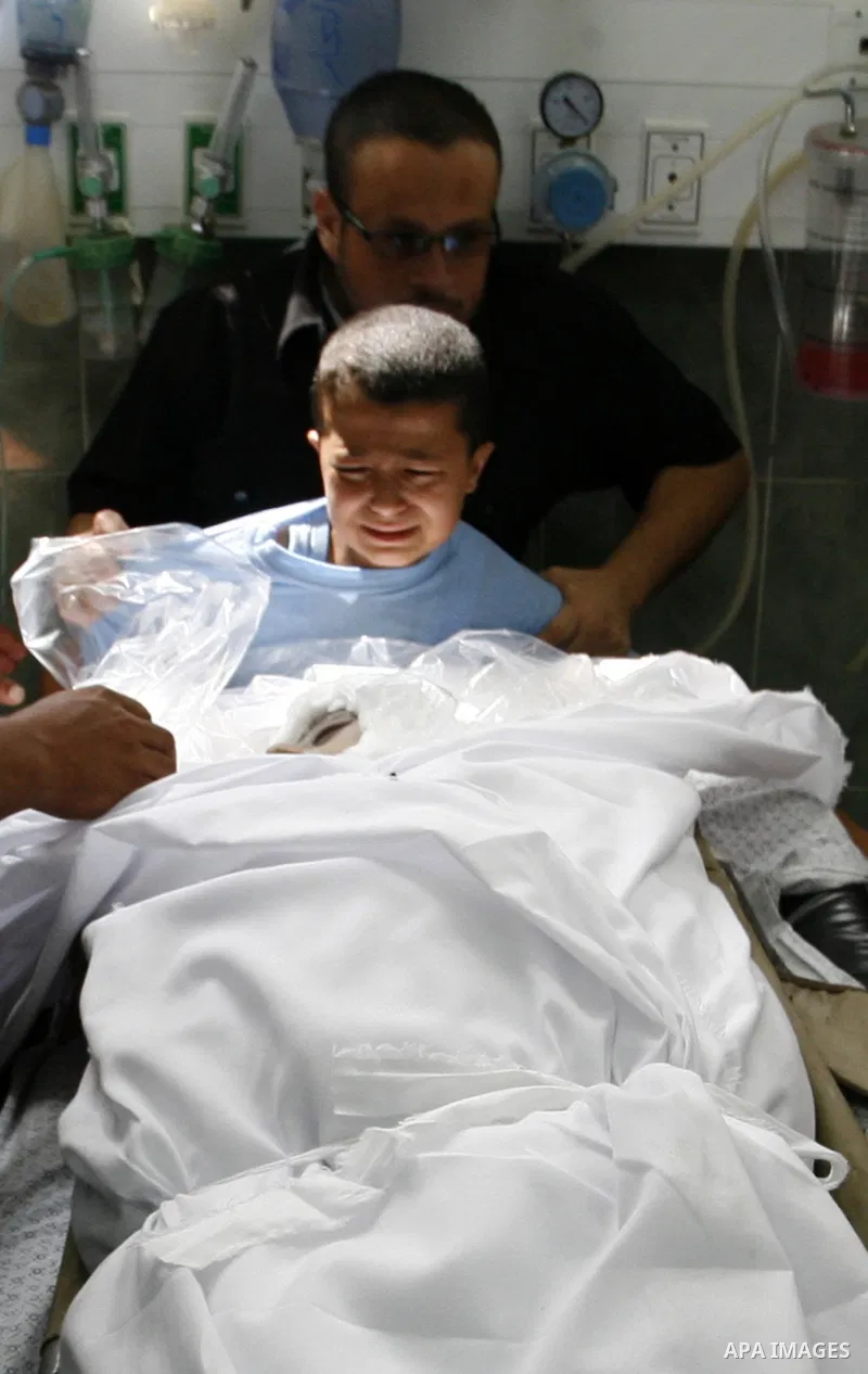 Palestinians mourn next to the body of Saleh al-Riyati, who witnesses said was killed in an Israeli air strike, at Abu Yousef al-Najjar hospital, in Rafah in the southern in Gaza city, on Sep. 10, 2014. Photo by Abed Rah...