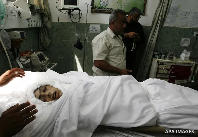 Palestinians mourn next to the body of Saleh al-Riyati, who witnesses said was killed in an Israeli air strike, at Abu Yousef al-Najjar hospital, in Rafah in the southern in Gaza city, on Sep. 10, 2014. Photo by Abed Rah...