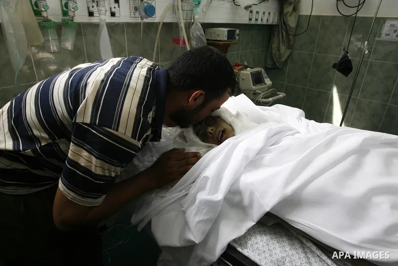 Palestinians mourn next to the body of Saleh al-Riyati, who witnesses said was killed in an Israeli air strike, at Abu Yousef al-Najjar hospital, in Rafah in the southern in Gaza city, on Sep. 10, 2014. Photo by Abed Rah...