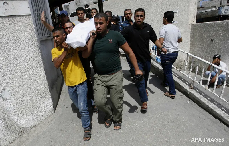 Palestinians carry the body of Saleh al-Riyati, who witnesses said was killed in an Israeli air strike, during his funeral at Abu Yousef al-Najjar hospital, in Rafah in the southern in Gaza city, on Sep. 10, 2014. Photo...