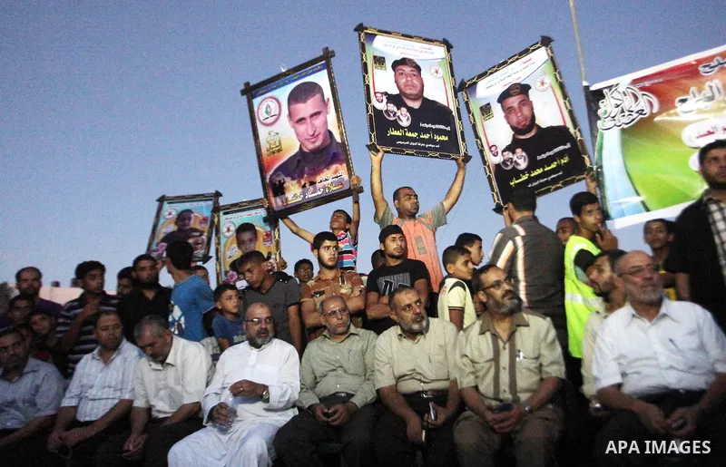 Palestinians hold pictures of their relatives who were killed during the Israeli offensive during the visit of Senior leader of Hamas Ismail Haniyeh in the Deir al-Balah in the central Gaza Strip, on September 10, 2014....