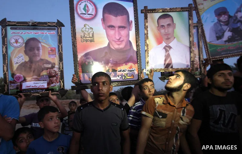 Palestinians hold pictures of their relatives who were killed during the Israeli offensive during the visit of Senior leader of Hamas Ismail Haniyeh in the Deir al-Balah in the central Gaza Strip, on September 10, 2014....