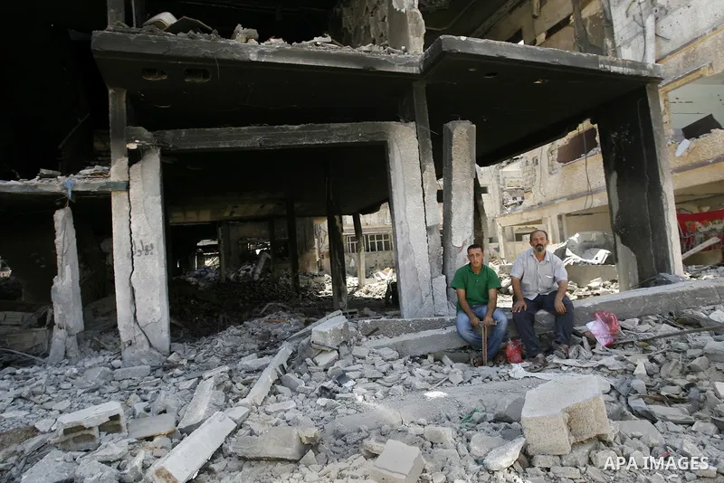 Palestinians set near destroyed houses in Khan Yunis in the southern Gaza Strip on September 11, 2014. Israel's deputy foreign minister,Tzahi Hanegbi , warned that Hamas was likely to resume "violence" if it feels it has...