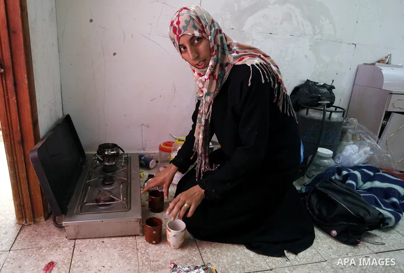 A Palestinian woman prepares tea in a destroyed house in Khan Yunis in the southern Gaza Strip on September 11, 2014. Israel's deputy foreign minister,Tzahi Hanegbi , warned that Hamas was likely to resume "violence" if...