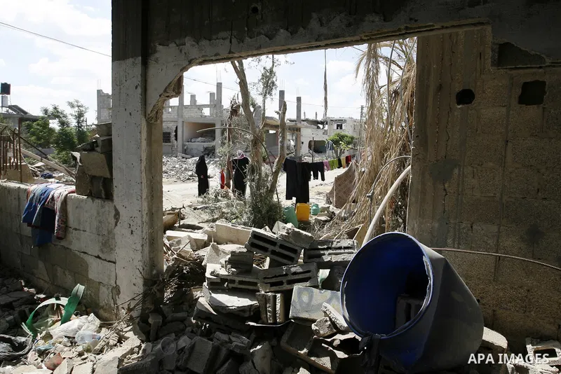 Palestinians stand near a destroyed house in Khan Yunis in the southern Gaza Strip on September 11, 2014. Israel's deputy foreign minister,Tzahi Hanegbi , warned that Hamas was likely to resume "violence" if it feels it...