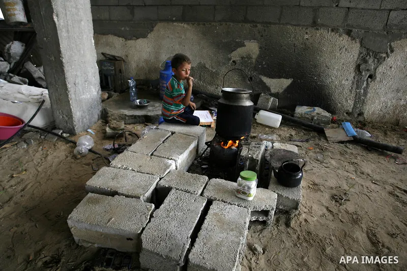 A Palestinian boy sits near firewood in a destroyed house in Khan Yunis in the southern Gaza Strip on September 11, 2014. Israel's deputy foreign minister,Tzahi Hanegbi , warned that Hamas was likely to resume "violence"...