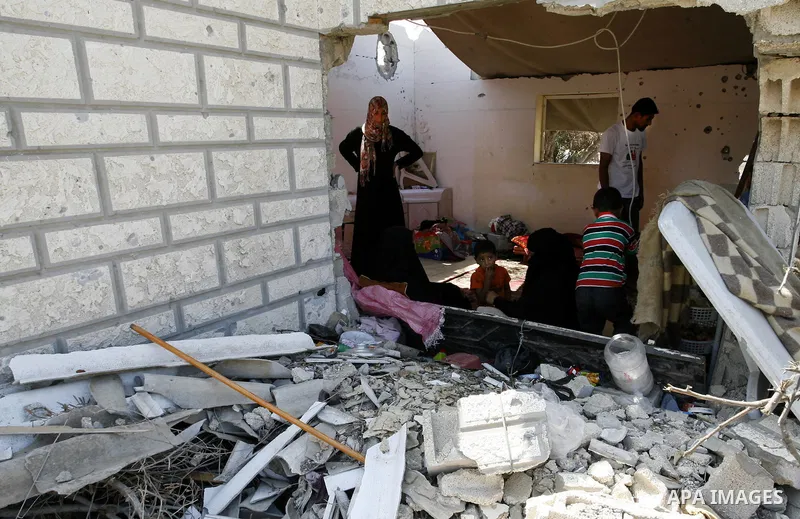Palestinians set in their destroyed house in Khan Yunis in the southern Gaza Strip on September 11, 2014. Israel's deputy foreign minister,Tzahi Hanegbi , warned that Hamas was likely to resume "violence" if it feels it...
