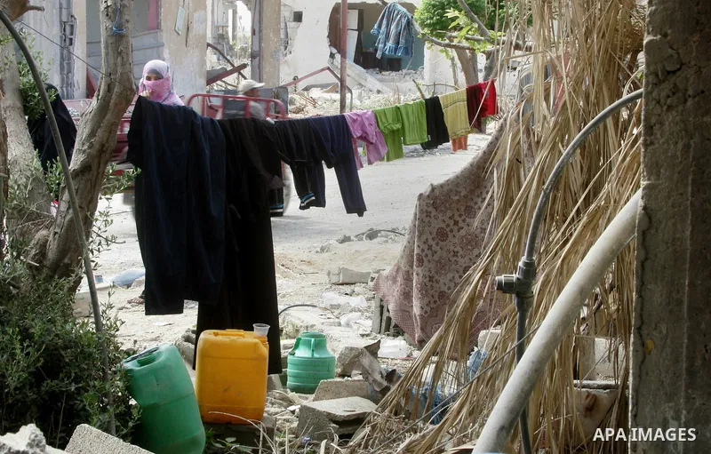 A Palestinian woman walks past a destroyed house in Khan Yunis in the southern Gaza Strip on September 11, 2014. Israel's deputy foreign minister,Tzahi Hanegbi , warned that Hamas was likely to resume "violence" if it fe...