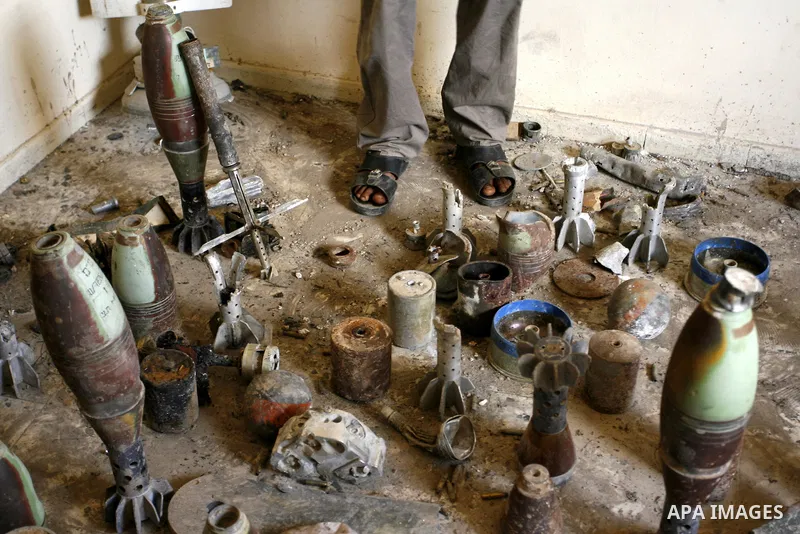 Palestinian resident, Suleiman Abu Jamaa, 35, stands next to mortars and other types of ammunition that he collected around his destroyed home in Khan Yunis in the southern Gaza Strip on September 11, 2014. Israel's depu...