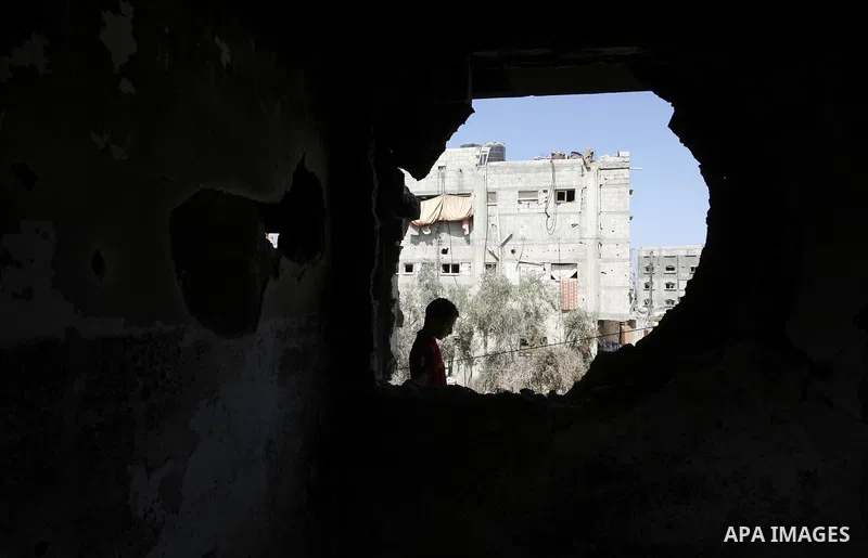 A Palestinian boy looks throw a hole in a destroyed house in Khan Yunis in the southern Gaza Strip on September 11, 2014. Israel's deputy foreign minister,Tzahi Hanegbi , warned that Hamas was likely to resume "violence"...
