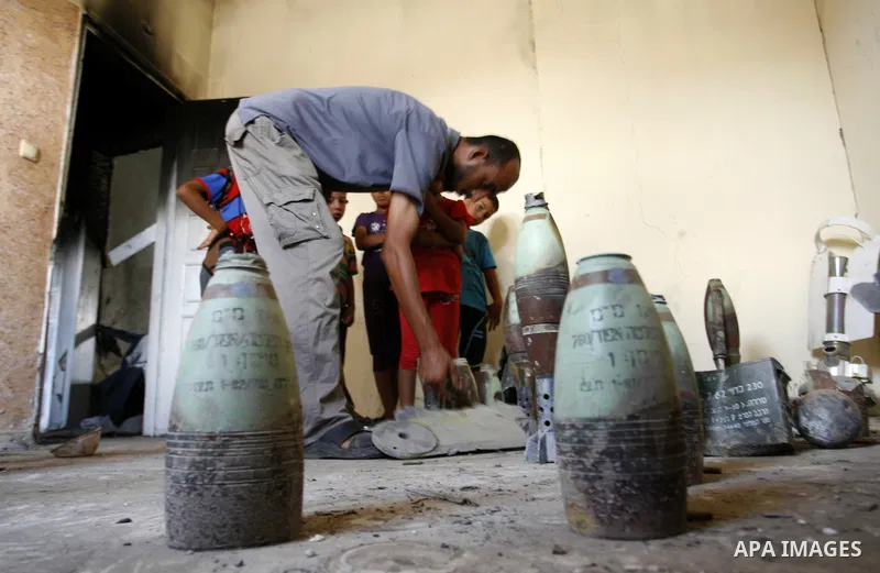 Palestinian resident, Suleiman Abu Jamaa, 35, displays mortars and other types of ammunition that he collected around his destroyed home in Khan Yunis in the southern Gaza Strip on September 11, 2014. Israel's deputy for...
