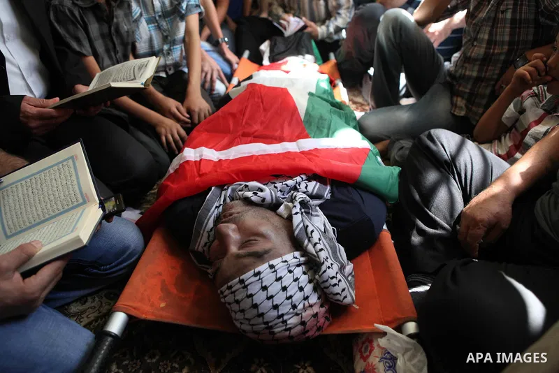 Relatives and friends gather around the body of Palestinian Raed al-Jabari, 35, during his funeral in the West Bank city of Hebron, September 12, 2014. Al-Jabari died on Tuesday in Israel's Soroka Medical Center after Pa...