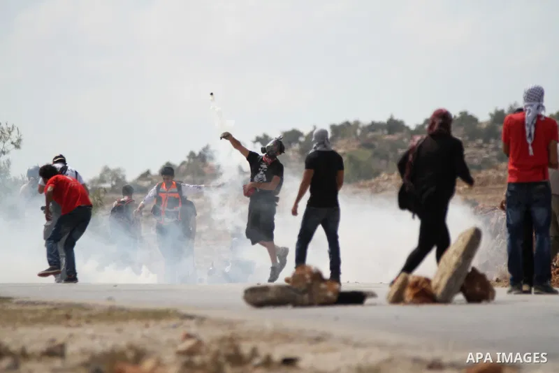 Palestinian protesters return tear gas canister during clashes with Israeli troops at a weekly protest against Jewish settlements, in the West Bank village of Nabi Saleh, near Ramallah September 12, 2014. Photo by Shadi...