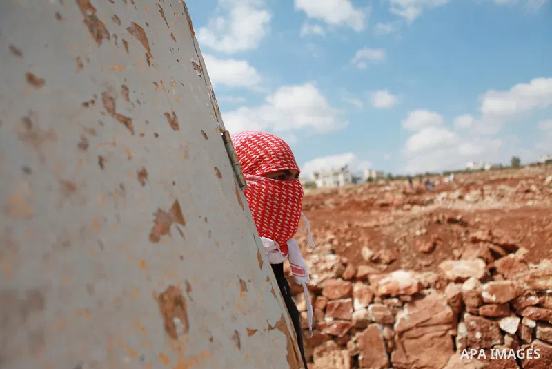 A Palestinian protester takes cover during clashes with Israeli troops at a weekly protest against Jewish settlements, in the West Bank village of Nabi Saleh, near Ramallah September 12, 2014. Photo by Shadi Hatem