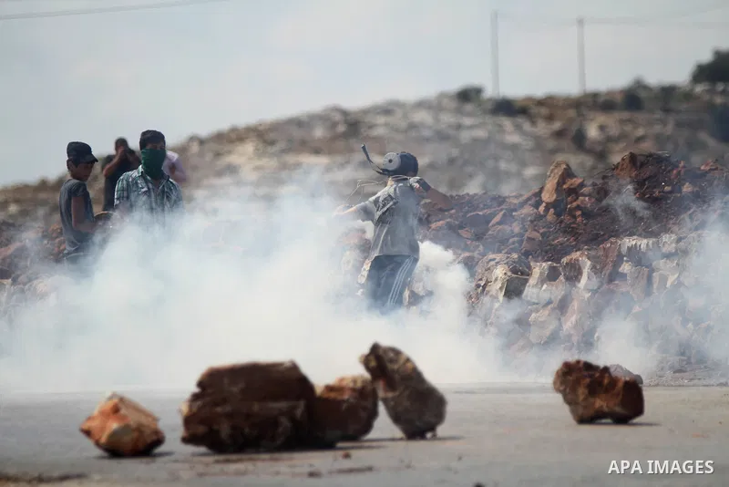 Palestinian protesters take cover from tear gas during clashes with Israeli troops at a weekly protest against Jewish settlements, in the West Bank village of Nabi Saleh, near Ramallah September 12, 2014. Photo by Shadi...
