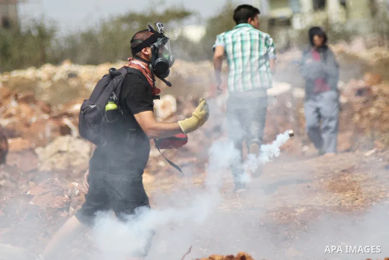 Palestinian protesters take cover from tear gas during clashes with Israeli troops at a weekly protest against Jewish settlements, in the West Bank village of Nabi Saleh, near Ramallah September 12, 2014. Photo by Shadi...