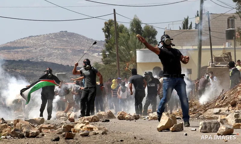 Palestinian protesters throw stones towards an Israeli security forces during clashes following a protest in the village of Kfar Qaddum, near the northern city of Nablus, in the occupied West Bank on September 12, 2014....