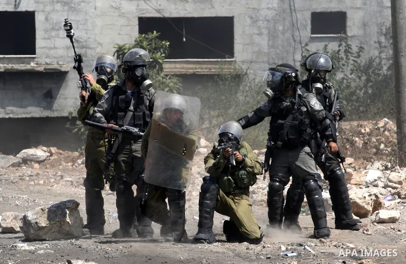 Israeli security forces fire tear gas towards Palestinian protesters during clashes following a protest in the village of Kfar Qaddum, near the northern city of Nablus, in the occupied West Bank on September 12, 2014. Ph...
