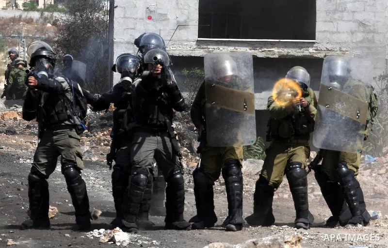 Israeli security forces fire tear gas towards Palestinian protesters during clashes following a protest in the village of Kfar Qaddum, near the northern city of Nablus, in the occupied West Bank on September 12, 2014. Ph...