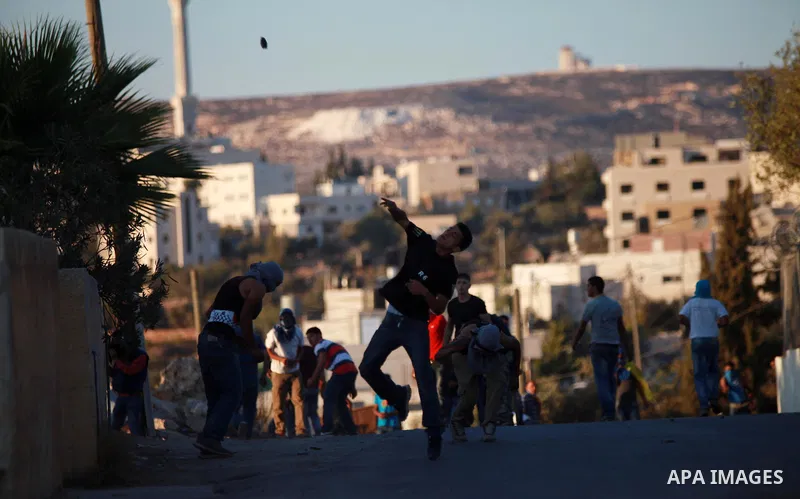 Palestinian protesters throw stones at Israeli security forces during clashes at a protest against the Jewish settlement of Ofra, in the West Bank village of Silwad, near Ramallah September 12, 2014. Photo by Shadi Hatem