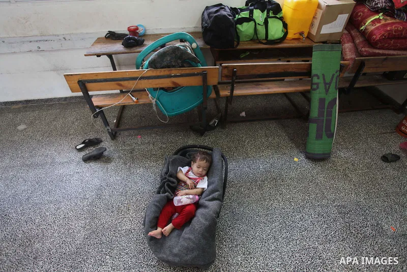 A displaced Palestinian child sleeps at class in a United Nations-run school, in Gaza city, on Sept. 13, 2014. Some 34 school buildings in Gaza are damaged beyond repair and 31 more are still being used as shelters, whil...